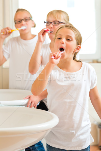 Girls tooth brushing in the bath room Stock photo © Kzenon