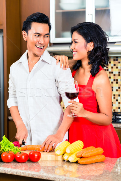 Stock photo: Asian couple preparing food in domestic kitchen