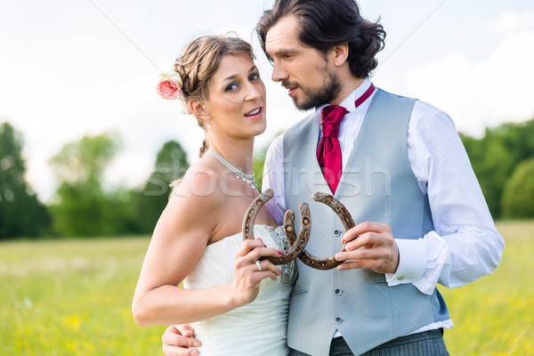 Wedding couple showing horse shoe Stock photo © Kzenon