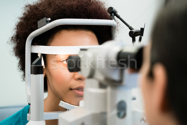 Woman having eyes measured with refractometer Stock photo © Kzenon