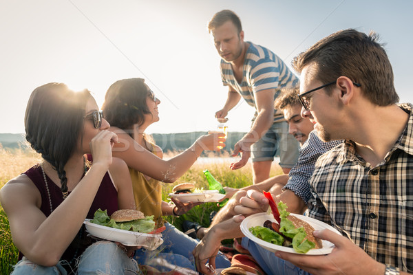 Friends having summer BBQ picnic and eating together Stock photo © Kzenon