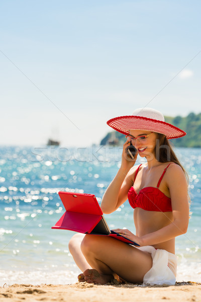 Fashionable young woman talking on mobile phone on the beach Stock photo © Kzenon