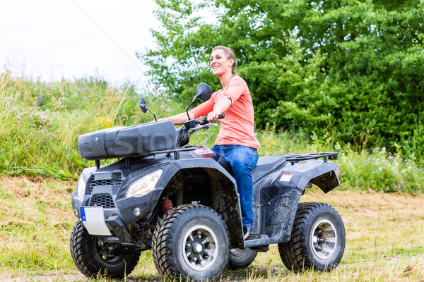 Stock photo: Woman driving off-road with quad bike or ATV