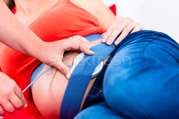 Belly of pregnant women with CTG scanning being adjusted Stock photo © Kzenon