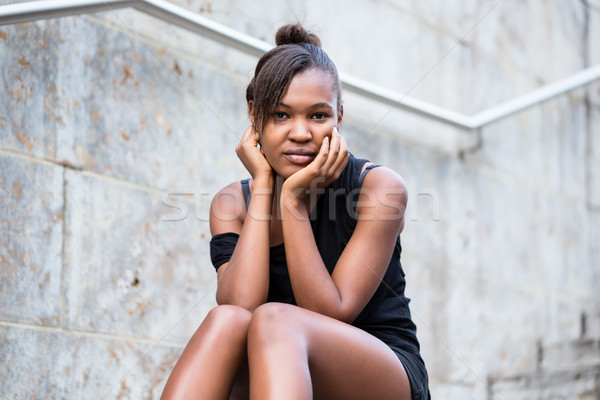 Portrait of young African American woman looking at camera while Stock photo © Kzenon