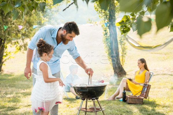 Foto stock: Nina · viendo · padre · carne · parrilla · de · la · barbacoa · familia