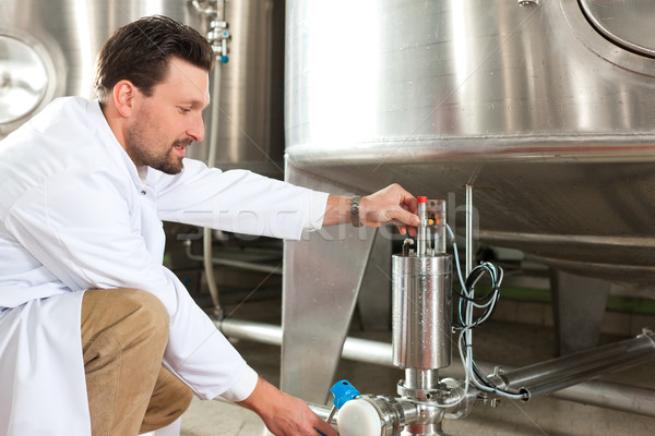 Beer brewer in his brewery at food tank Stock photo © Kzenon