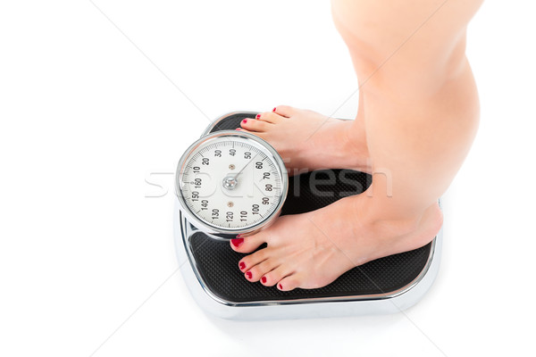 Stock photo: Young woman standing on a scale