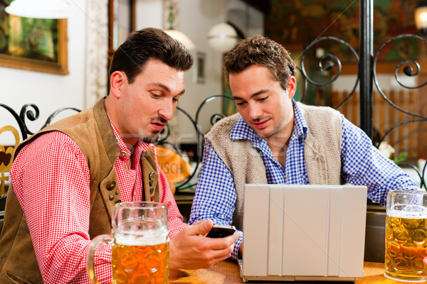 Two friends in Bavarian pub with laptop Stock photo © Kzenon