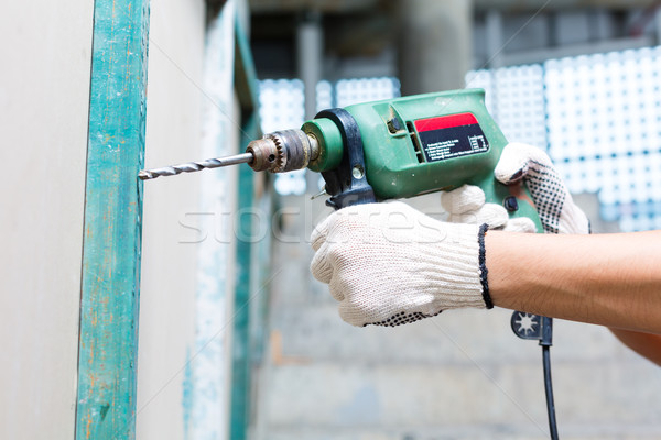 worker drilling with machine in construction site wall Stock photo © Kzenon