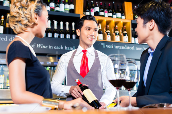 Stock photo: Asian couple tasting red wine in bar