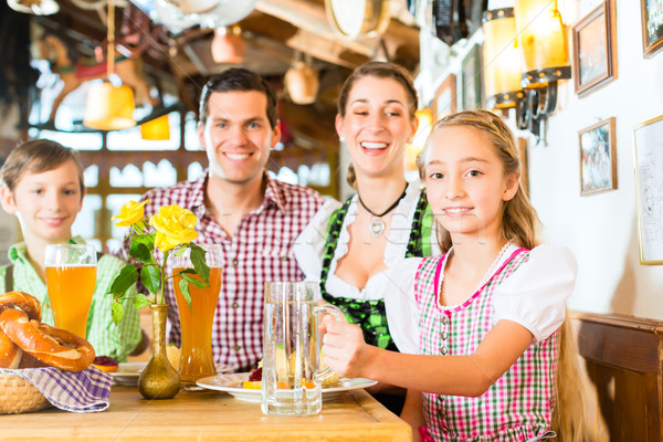 Bavarian girl with family in restaurant  Stock photo © Kzenon