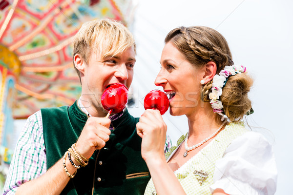 Couple in Bavarian clothes eating candy apples  Stock photo © Kzenon