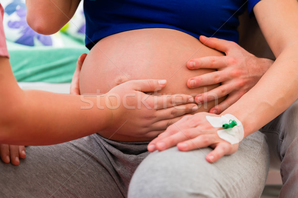 Midwife or nurse feeling baby belly of pregnant woman Stock photo © Kzenon