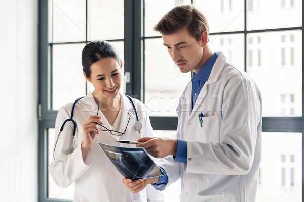 Two young dedicated doctors analyzing together a radiograph Stock photo © Kzenon