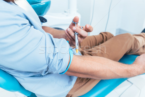 Patient using a dental anesthetic syringe for injecting himself  Stock photo © Kzenon