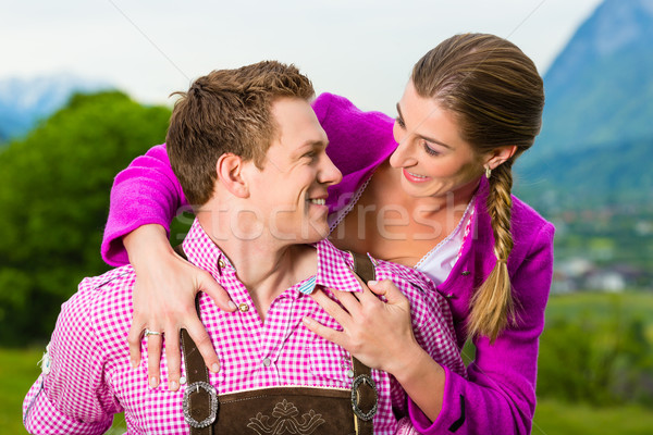 Happy couple in Alpine meadow in Tracht Stock photo © Kzenon