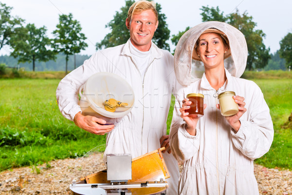 Stock photo: Beekeeper filling honey with extractor in glass 