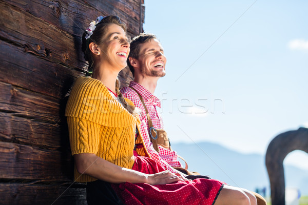 Couple in traditional clothing front of mountain hut Stock photo © Kzenon