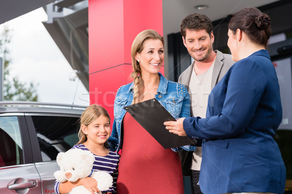 Car dealer advising family on buying auto Stock photo © Kzenon
