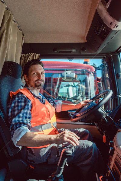 Lorry or truck driver sitting in the cabin of his vehicle Stock photo © Kzenon