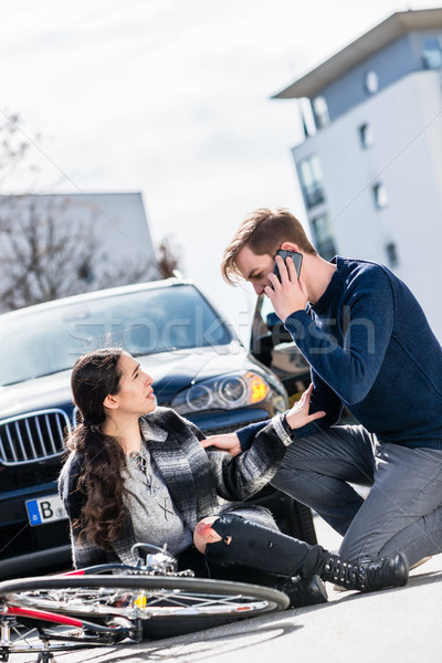 Young man calling the emergency services after hitting a bicyclist Stock photo © Kzenon