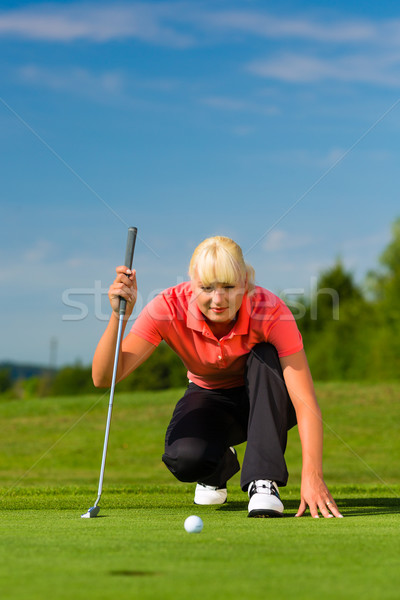 Young female golf player on course aiming for put Stock photo © Kzenon