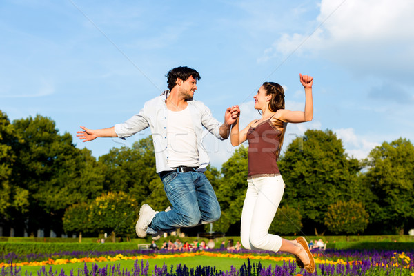 Tourist couple in city park jumping in sun Stock photo © Kzenon