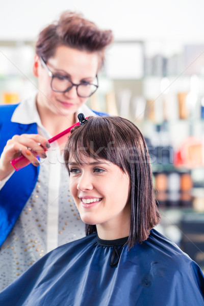 Hairdresser cutting woman hair in shop Stock photo © Kzenon