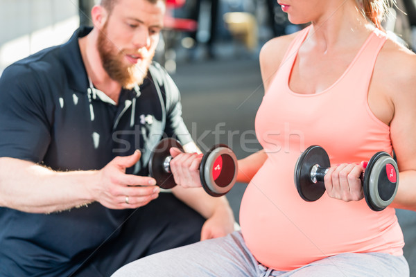 Terhes nő edz súlyzók személyi edző tornaterem nő Stock fotó © Kzenon