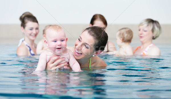 Group of mothers with children at baby swimming lesson Stock photo © Kzenon