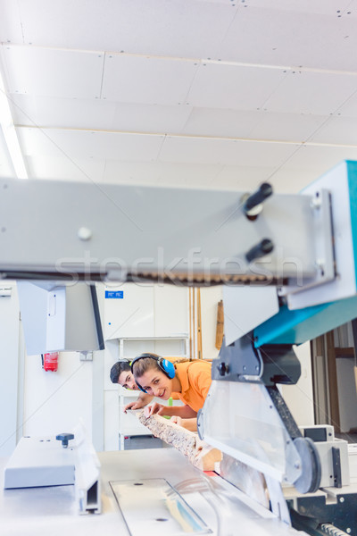 Man and woman carpenter cutting board Stock photo © Kzenon