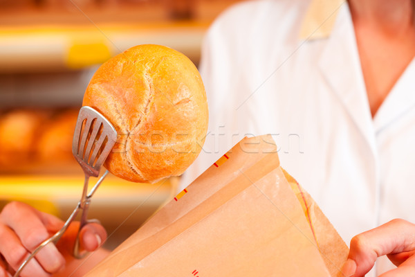 Salesperson is packing bread in bakery Stock photo © Kzenon