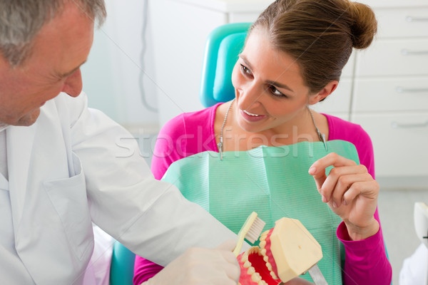 Dentist explaining teeth brushing to patient Stock photo © Kzenon