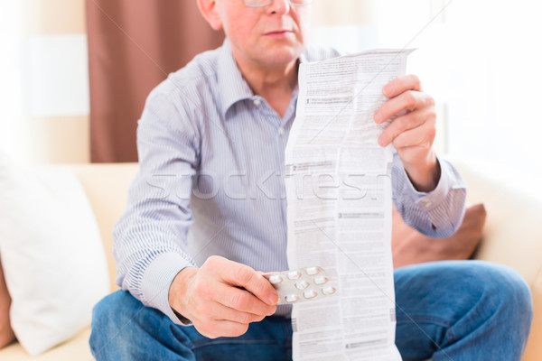 Senior reading  medicament package insert at home Stock photo © Kzenon