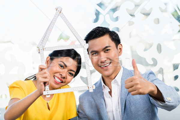 Asian couple with folding rule in furniture store Stock photo © Kzenon