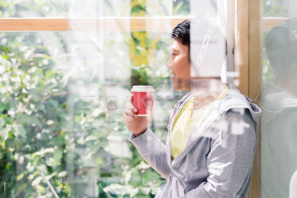 Young man day dreaming while drinking a coffee during break Stock photo © Kzenon