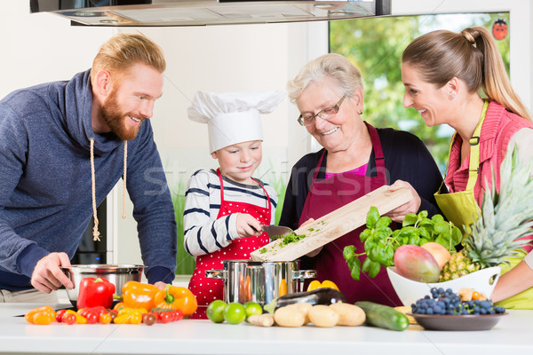 Family cooking in multigenerational household with son, mother,  Stock photo © Kzenon