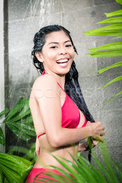 Asian woman using shower in tropical garden Stock photo © Kzenon