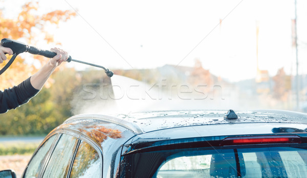 Stock photo: Worker cleaning car with high pressure water nozzle