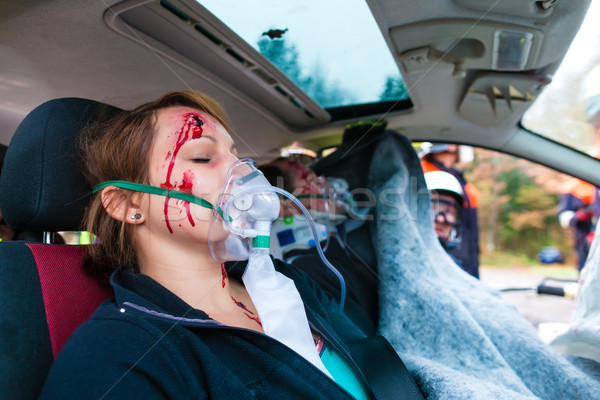 Car accident - Victim in crashed vehicle receiving first aid Stock photo © Kzenon