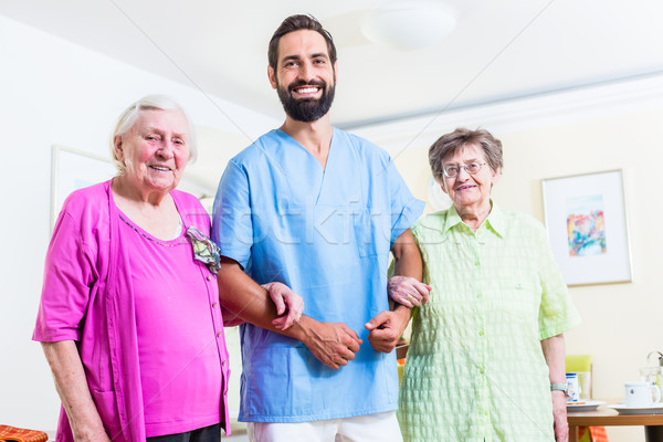 Caregiver with senior women in nursing home Stock photo © Kzenon