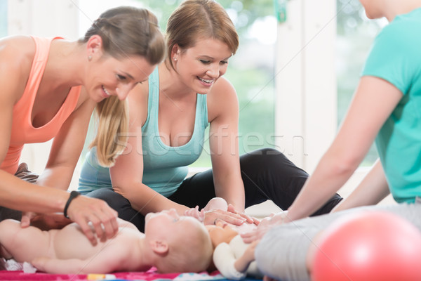 Young women practicing how to wrap children in mother-child less Stock photo © Kzenon