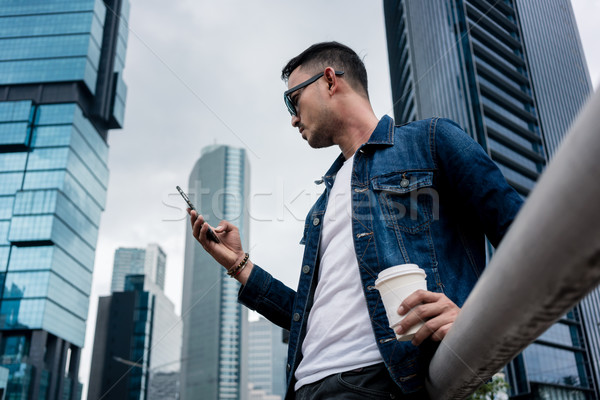 Młody człowiek smartphone odkryty dzielnica biznesowa widok z boku Zdjęcia stock © Kzenon