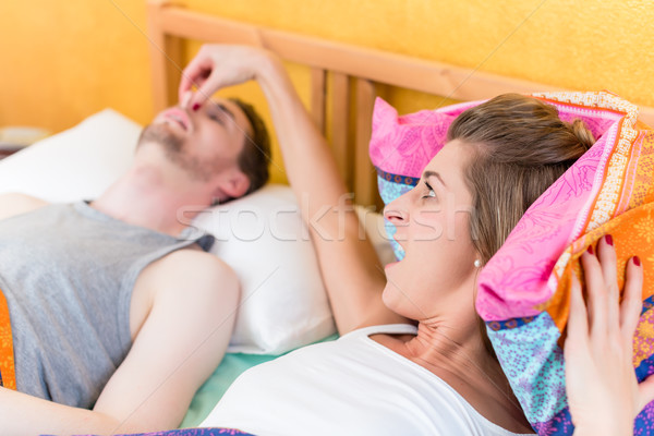 Woman is angry and holds nose of her snoring partner Stock photo © Kzenon