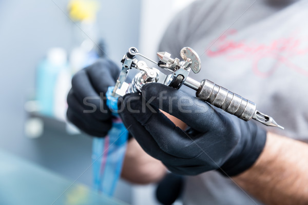 Close-up of the hands of a skilled tattoo artist wearing black gloves Stock photo © Kzenon