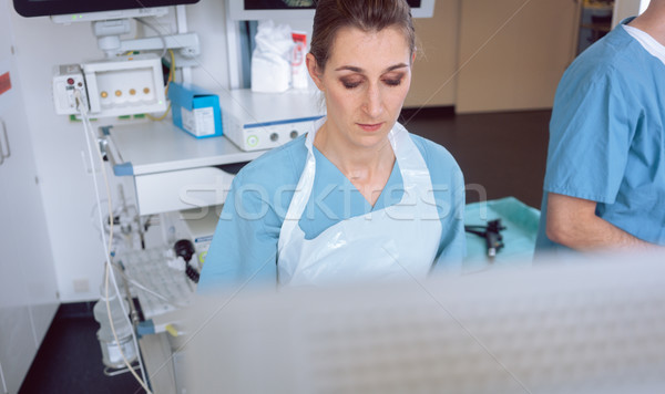 Internal specialist doctor looking at screen mid examination Stock photo © Kzenon