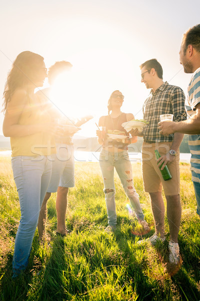 Group of friends standing in circle on barbecue party Stock photo © Kzenon