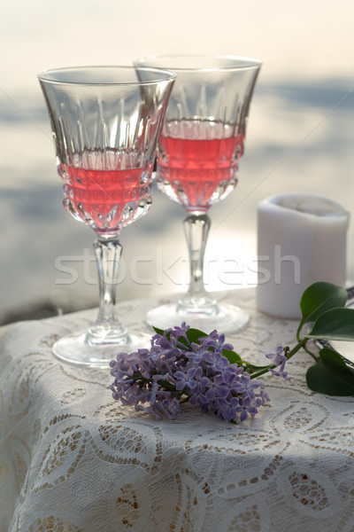 Two glas of pink wine and lilac on the table outdoors Stock photo © laciatek