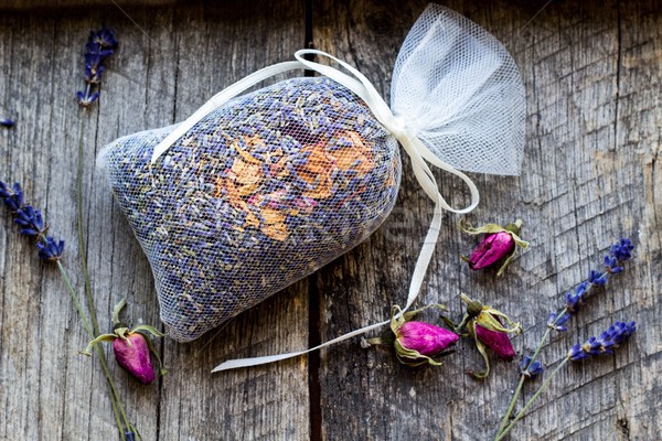 bag with wild roses petals and dried lavender flowers on wooden, vintage background - fragrance to t Stock photo © laciatek